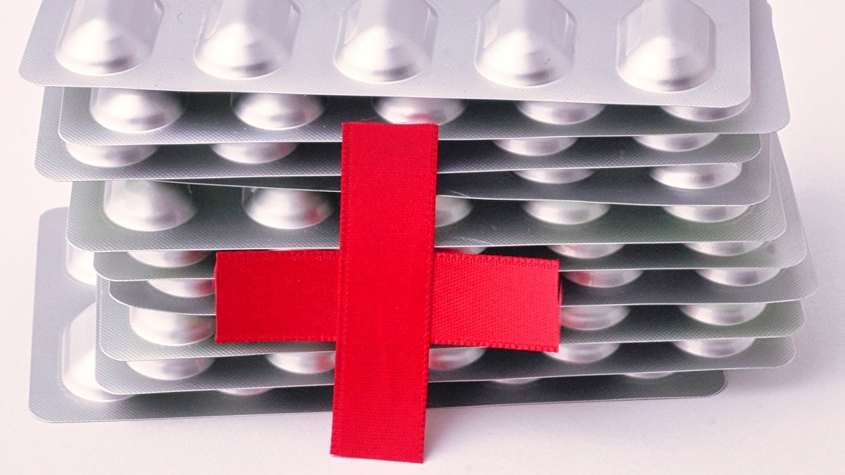 a red cross on top of a bunch of pills