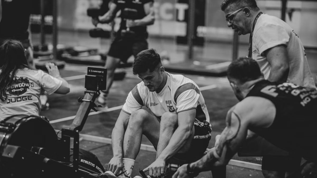 Men engaged in a competitive gym rowing session, highlighting teamwork and fitness.